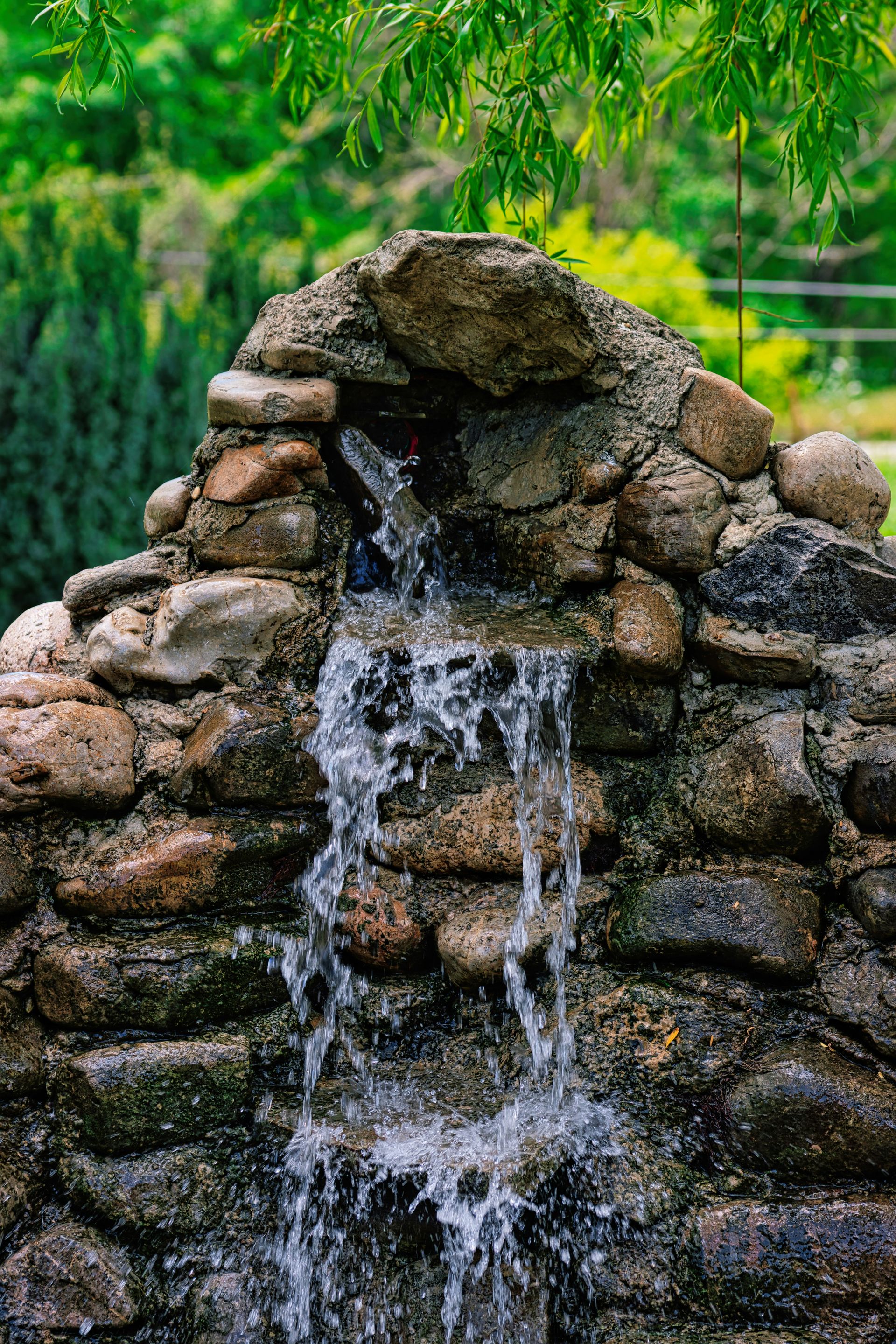 A small waterfall cascades over a stone structure